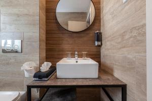 a bathroom with a white sink and a mirror at Pergola Hotel & Spa in Mellieħa