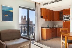 a kitchen with a view of the city at Pergola Hotel & Spa in Mellieħa