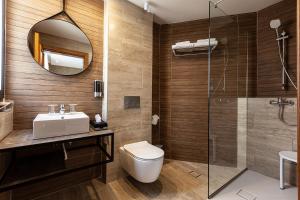 a bathroom with a toilet and a sink and a shower at Pergola Hotel & Spa in Mellieħa