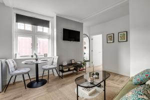 un soggiorno con divano, tavolo e sedie di Lovely Kensington Apartments a Londra