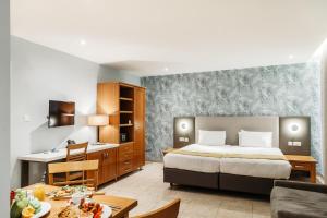 a hotel room with a bed and a desk at Pergola Hotel & Spa in Mellieħa