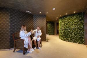 a man and a woman sitting in a room at Pergola Hotel & Spa in Mellieħa