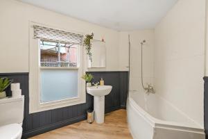 a bathroom with a sink and a tub and a toilet at Stunning Penthouse On Bristols Harbourside in Bristol