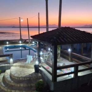 un edificio con piscina y puesta de sol en Pousada dos Pinheiros, en Guaraqueçaba