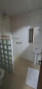 y baño con aseo y lavamanos. en Pousada dos Pinheiros, en Guaraqueçaba