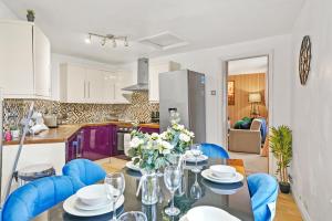 a kitchen and dining room with a table and blue chairs at Stunning Penthouse On Bristols Harbourside in Bristol
