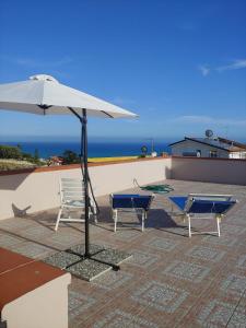 a patio with two chairs and an umbrella at apartament scala dei turchi e Piscina in Realmonte
