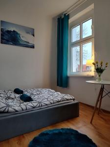 a bedroom with a bed and a table and a window at Benny 3 in Toruń