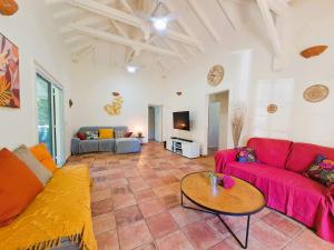 - un salon avec un canapé rouge et une table dans l'établissement Villa L'Orangeraie, à Le Moule