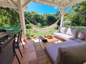 une terrasse avec un canapé et une table dans l'établissement Villa L'Orangeraie, à Le Moule
