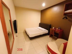 a small room with a bed and a small table at Doris Hotel in Melaka