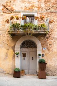 a building with a door and a balcony with potted plants at B&B Chez Nous - Città della Pieve in Città della Pieve