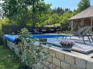 a swimming pool in a yard next to a brick wall at Casa Thymus in Soveja