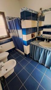 a blue tiled bathroom with a sink and a toilet at apartament scala dei turchi e Piscina in Realmonte