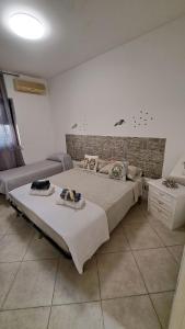 a bedroom with a large bed and a couch at apartament scala dei turchi e Piscina in Realmonte