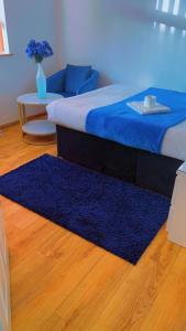 a bedroom with a blue bed and a blue rug at CHATHAM GUEST HOUSE in Chatham