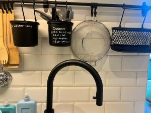a kitchen sink with utensils hanging on a wall at De Koer Kanne in Kanne