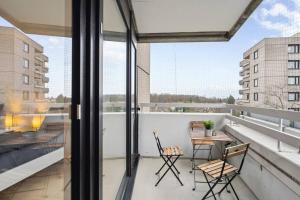 a balcony with two chairs and a table on it at OH05 Apartment in Flughafennähe! in Mörfelden-Walldorf