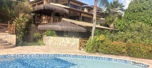 a resort with a swimming pool in front of a building at Apartamento PIPA - UF01 in Pipa