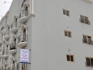 un panneau est apposé sur le côté du bâtiment dans l'établissement شقق لين, à Khobar