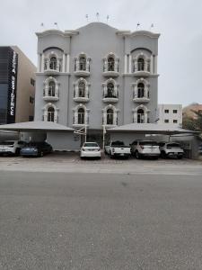 a large white building with cars parked in front of it at شقق لين in Al Khobar