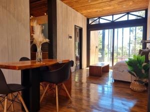 a dining room with a table and chairs and a bedroom at Surf Lodge Punta de Lobos in Pichilemu