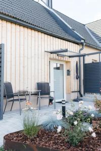 un patio con sillas y una mesa frente a un edificio en Pension Blumenwiese, en Burgau