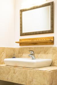 a sink in a bathroom with a mirror above it at Heart of Polen appartements in Piechowice