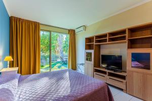 um quarto com uma cama, uma televisão e uma janela em Appartamento Sanremo em Sanremo