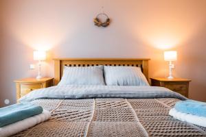 a bedroom with a bed with two lamps on two tables at Heart of Polen appartements in Piechowice