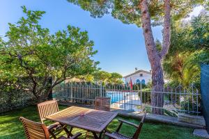 a wooden table and chairs next to a fence at Appartamento Sanremo in Sanremo