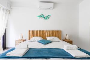 a bedroom with a large bed with a blue pillow at LA PERLE 2 P Terrasse Vue Mer 1min Plage Clim in Roquebrune-Cap-Martin