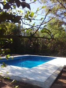 una piscina azul con una valla y árboles en ALMA CALMA en San Marcos Sierras