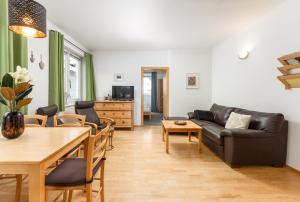 ein Wohnzimmer mit einem Sofa und einem Tisch in der Unterkunft Appartmenthaus Centro by Schladming-Appartements in Schladming