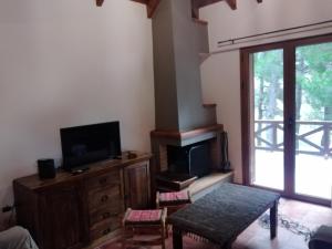 sala de estar con TV y centro de entretenimiento de madera en View suites, en Arachova