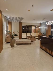 a lobby with couches and a waiting room with a plant at Hotel Mãe Morena in Aparecida