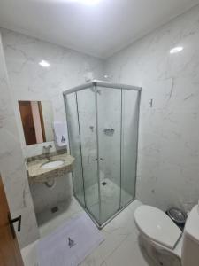 a bathroom with a shower and a toilet and a sink at Hotel Mãe Morena in Aparecida