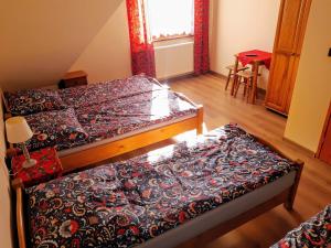 1 dormitorio con 2 camas, mesa y ventana en Willa Wyrostek, en Bańska Wyżna