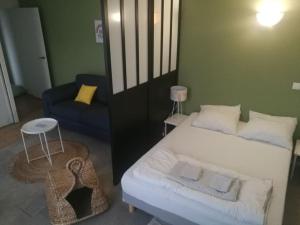 a bedroom with a white bed and a blue couch at Bordeaux Downtown, pool access in Bordeaux
