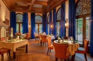 una sala da pranzo con tavoli, sedie e pareti blu di La Villa des Orangers - Relais & Châteaux a Marrakech