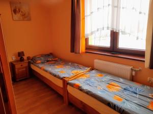 1 dormitorio con 2 camas individuales y ventana en Willa Wyrostek, en Bańska Wyżna