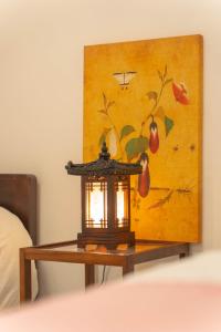 eine Lampe auf einem Tisch vor einem Gemälde in der Unterkunft Soo Stay-4bed&Double Room, Hongdae, Sinchon 10min in Seoul