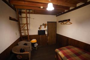 Zimmer mit einem Bett, einer Leiter und einer Tür in der Unterkunft 白馬シェア 落倉店 Hakuba share-Ochikura in Yotsuya