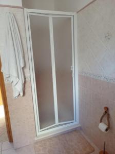 una doccia con porta in vetro in bagno di Casa di Peppe o'Biond a Procida