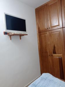 a flat screen tv on a wall next to a wooden cabinet at Casa di Peppe o'Biond in Procida