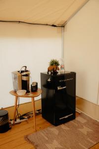 a black refrigerator in a room with a table at Glamping Tents 2 Queens at Lake Guntersville State Park in Guntersville