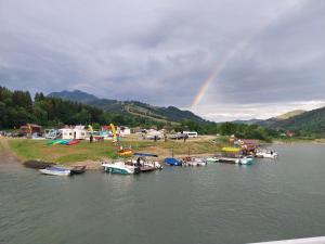 a rainbow over a group of boats in the water at Pensiunea TOTAL din Ceahlău in Ceahlău
