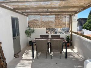a patio with a table and chairs on a balcony at Casa Porta Velha 2 Bed in Tavira