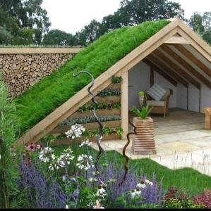 d'un kiosque avec un toit verdoyant dans le jardin. dans l'établissement Caravans Park & GLAMPING TENTS in the Vineyard, à Turda