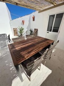 a wooden table and chairs on a patio at Casa Porta Velha 2 Bed in Tavira